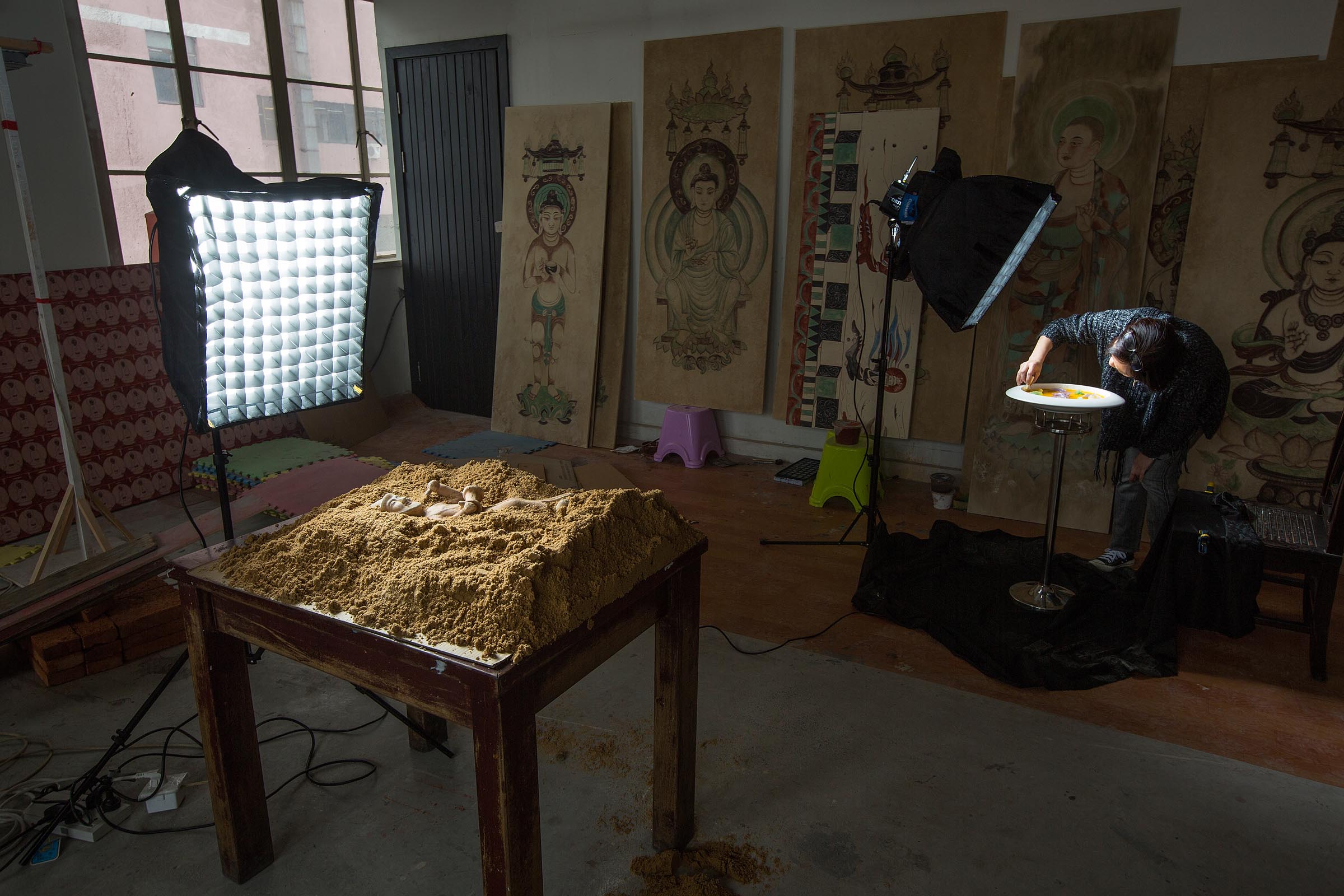 Edwige Chang, marketing director for Lost Heaven, cleans a plate while a buried statue waits for his close-up. © David Hartung