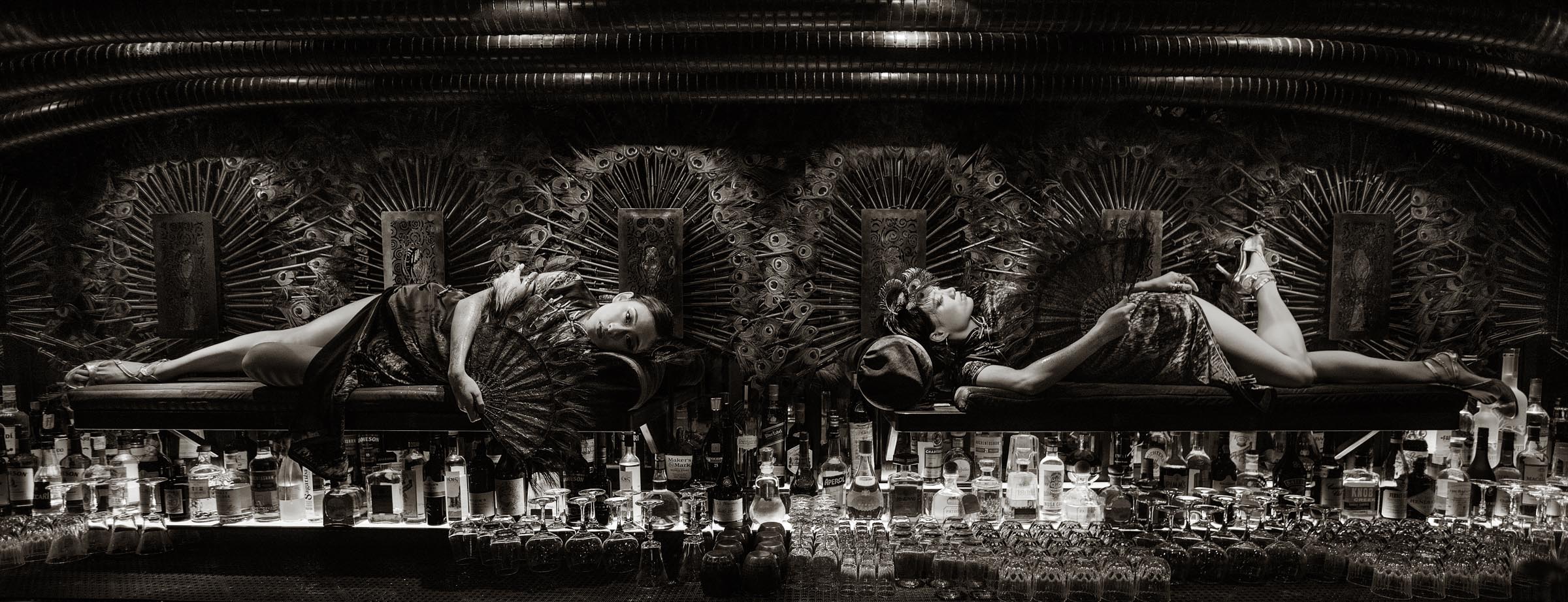 Performers lay on opium beds mounted to the wall above the bar at Ophelia.